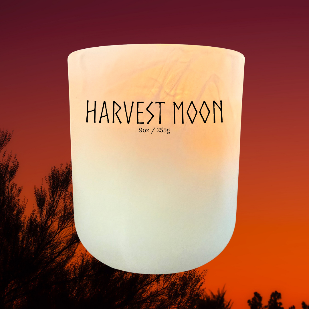 Harvest Moon soy candle with glowing sunset background – handmade cinnamon, apple, and cedar fragrance inspired by autumn evenings